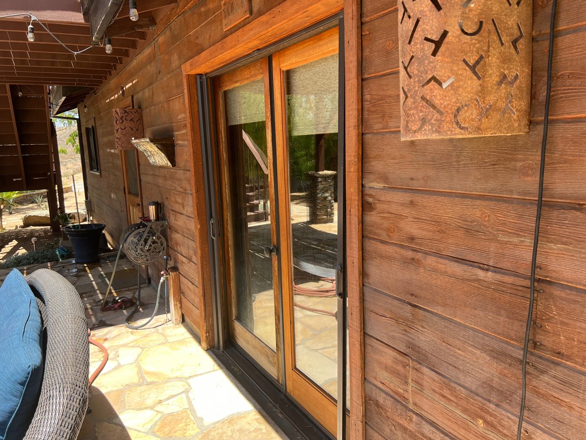 Wood-sided home seen from the driveway after refinishing